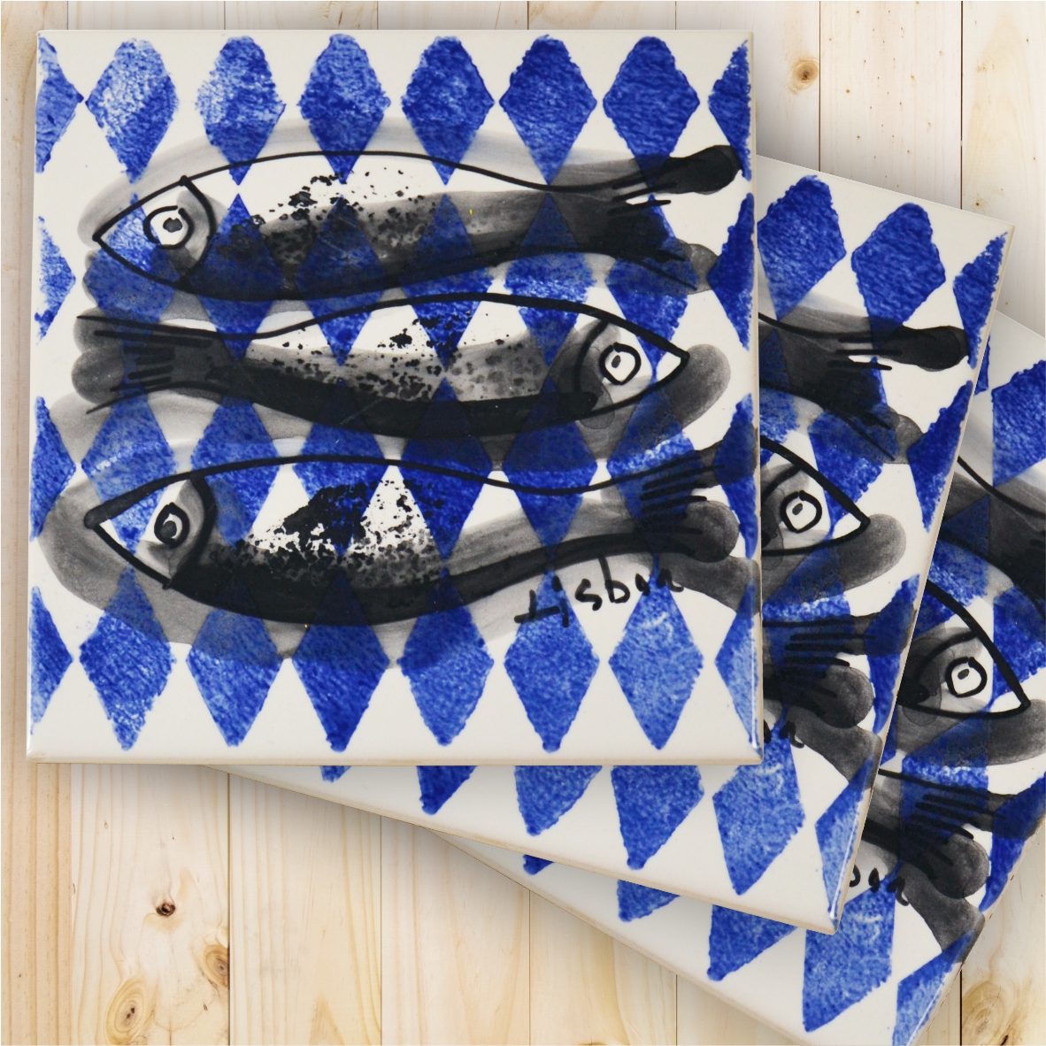 Square ceramic tiles with black fish and blue diamond pattern on white background