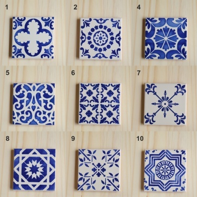 Nine blue and white patterned ceramic tiles numbered 1 to 10 with tile 3 missing on wooden surface