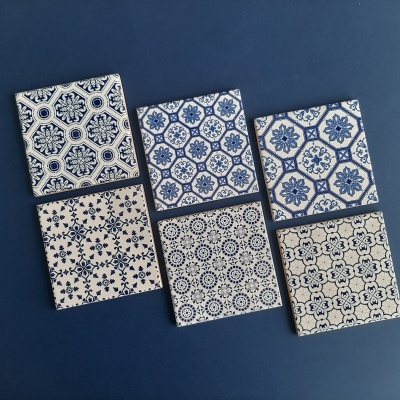 Six blue and white patterned ceramic tiles on blue background