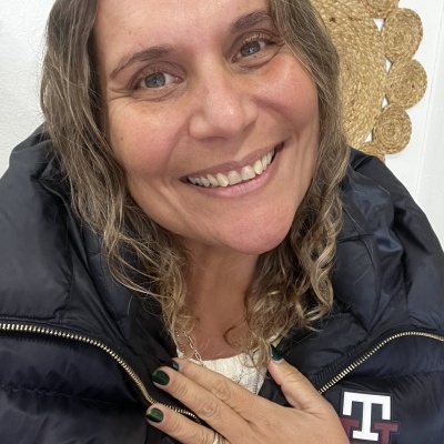 Mulher a sorrir com casaco acolchoado preto e anéis