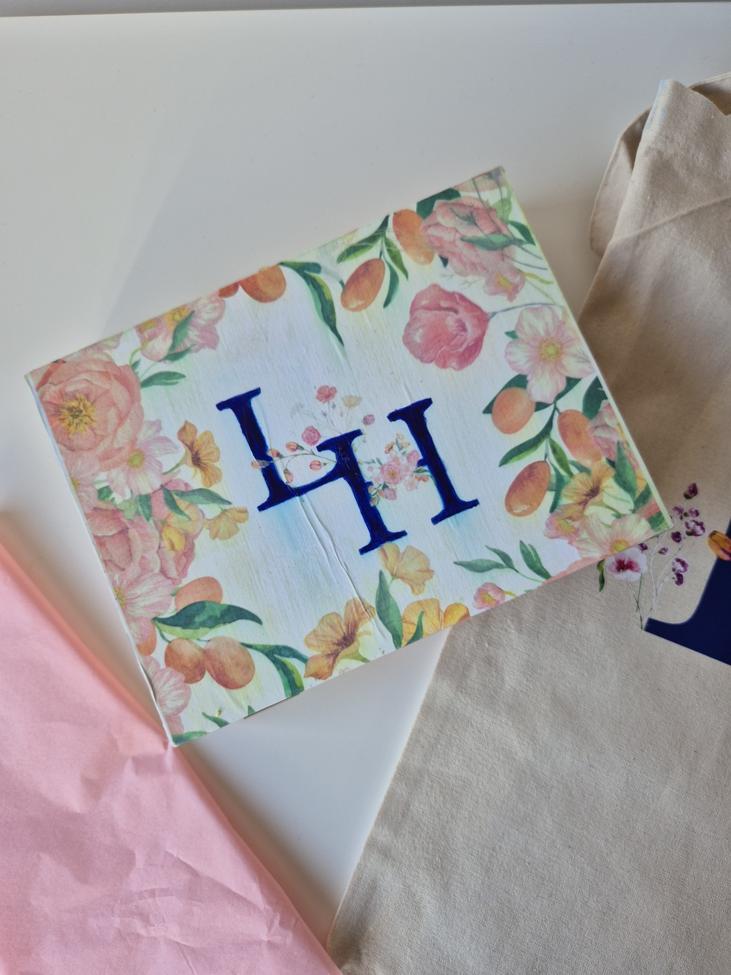 Guarda-napo floral branco com letras HI azuis