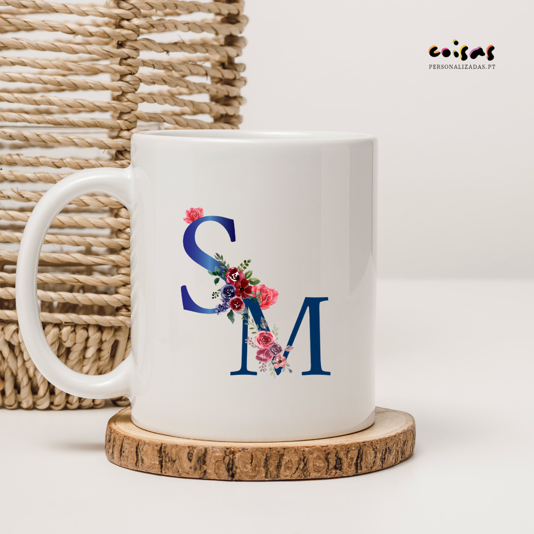 Cana branca com letras azuis e flores coloridas sobre descanso de madeira