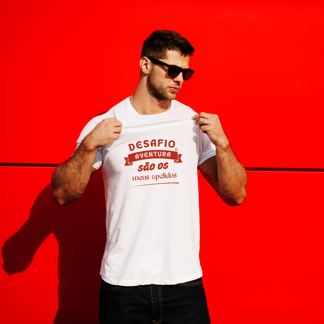 Homem com t-shirt branca com texto em vermelho e preto num fundo vermelho