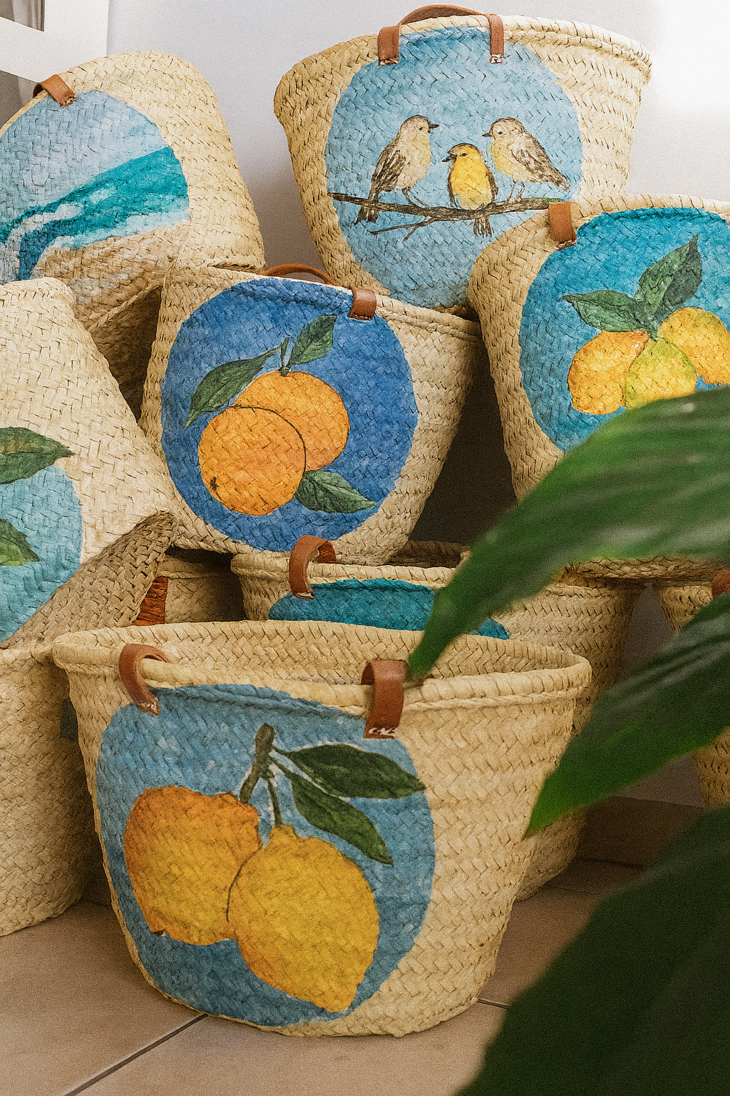 Cestos de palha com pinturas de frutas e pássaros em fundo azul