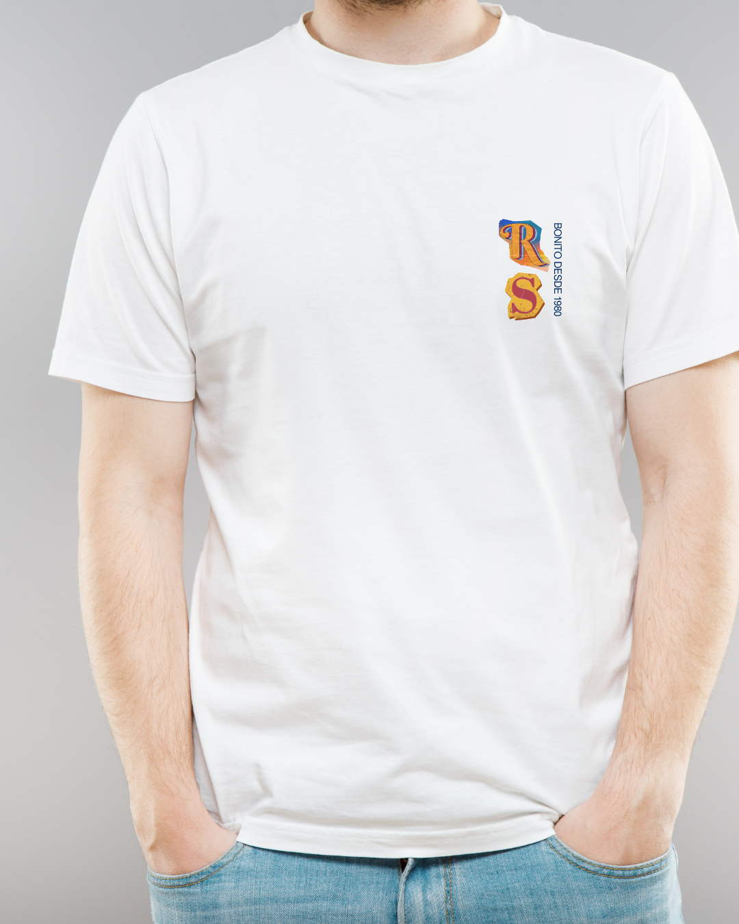 Homem com t-shirt branca de manga curta com estampa azul e amarelo e calças de ganga azuis