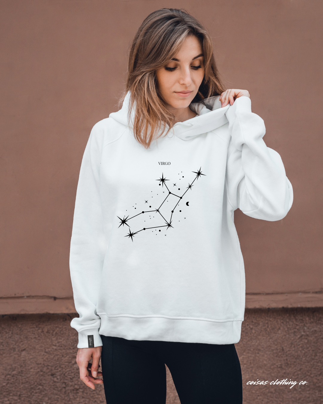 Mulher a usar sweatshirt branca com capuz e estampa da constelação Virgem