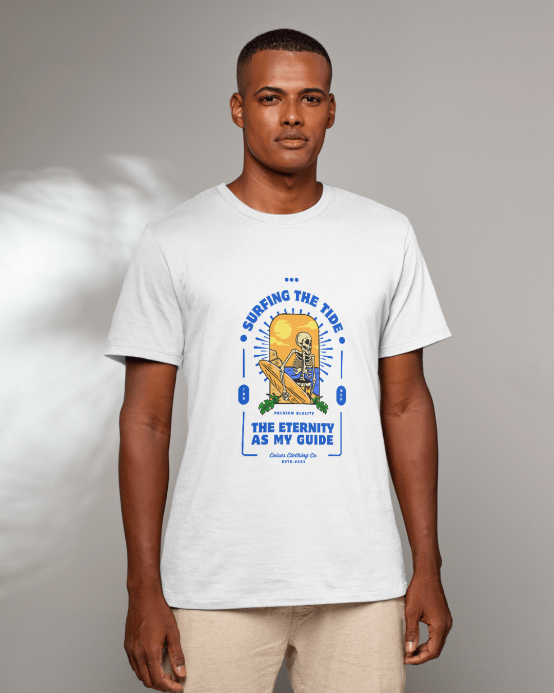T-shirt branca com estampado de esqueleto a surfar e texto em azul e amarelo