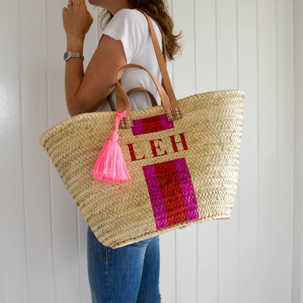 Saco de palha com alças de couro e decoração em rosa e vermelho
