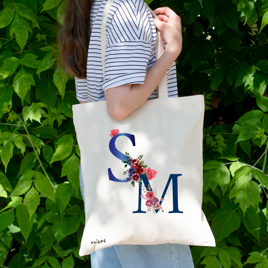 Saco de tecido branco com letras S e M decoradas com flores coloridas