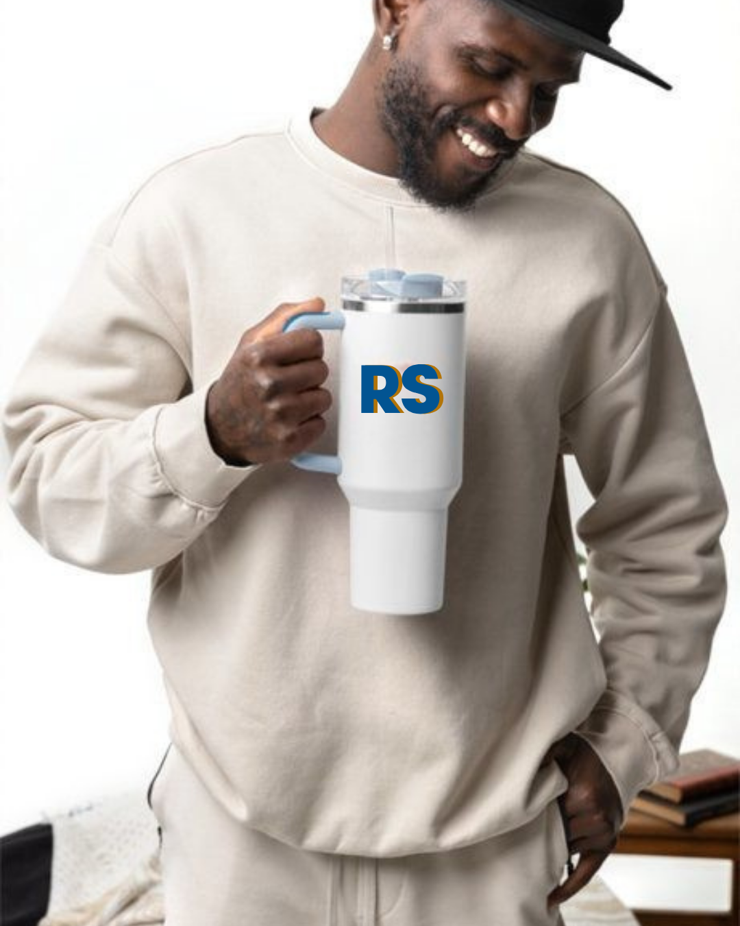 Homem a segurar copo térmico branco com letras 'RS' em azul e amarelo