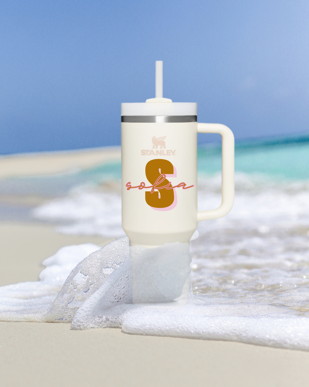 Copo isolante creme com tampa branca e canudo na praia