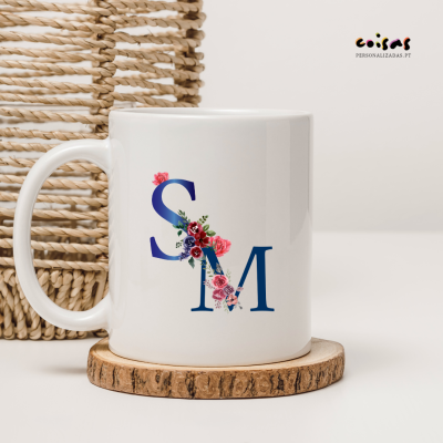 Cana branca com letras azuis e flores coloridas sobre descanso de madeira