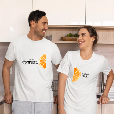 Casal com t-shirts brancas estampadas, na cozinha.