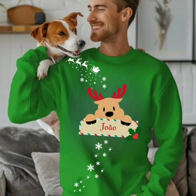 Camisola verde com rena e nome João, homem sorridente com cão na sala