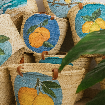 Cestos de palha com pinturas de frutas e pássaros em fundo azul