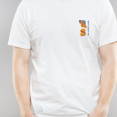 Homem com t-shirt branca de manga curta com estampa azul e amarelo e calças de ganga azuis