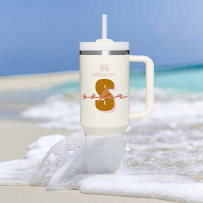 Copo isolante creme com tampa branca e canudo na praia