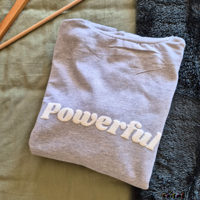 Sweatshirt cinzenta clara dobrada com palavra bordada 'Powerful'