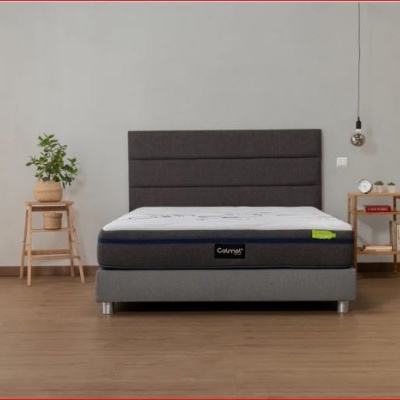 Cama de casal com colchão branco e base cinzenta num quarto minimalista