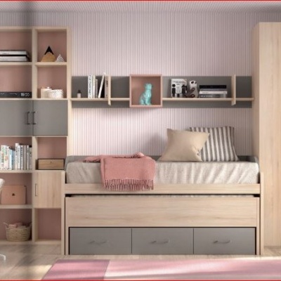 Quarto infantil com cama e móveis de madeira clara, parede rosa, cadeira de cortiça e mesa branca com computador