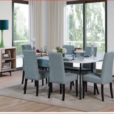 Sala de jantar com mesa branca e cadeiras cinzentas, aparadores brancos com candeeiros verdes e quadro na parede.