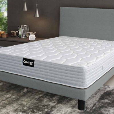 Cama com colchão branco e estrutura cinza numa sala moderna