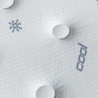 Colchão branco com bordados de flocos de neve azuis e botões acolchoados.