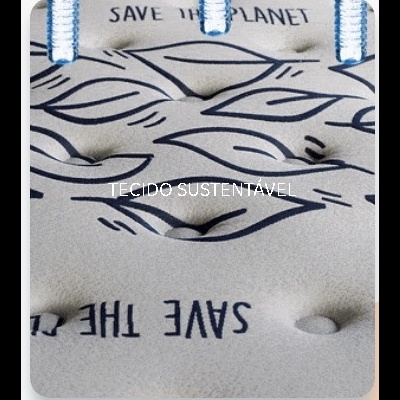 Colchão cinza claro com padrão de folhas azuis e texto ecológico