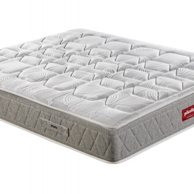 Colchão cinzento claro acolchoado com etiquetas vermelhas e padrão quadriculado nas bordas.