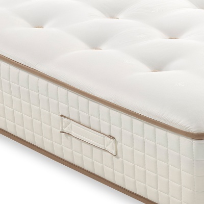 Colchão branco acolchoado com alça lateral e borda castanha