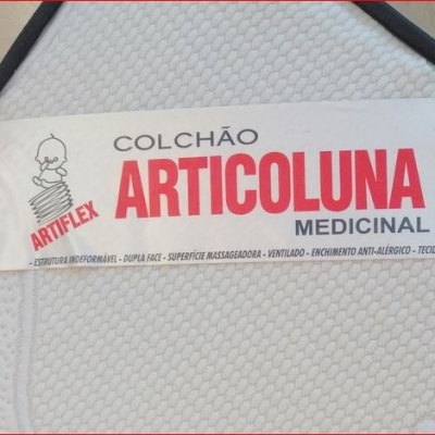 Colchão branco com etiqueta COLCHÃO ARTICOLUNA MEDICINAL e borda preta