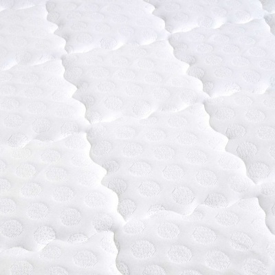 Colchão branco acolchoado com padrão de hexágonos e círculos em relevo