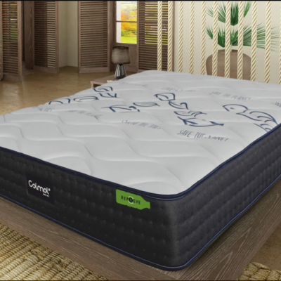 Colchão com capa branca e laterais pretas numa cama de madeira dentro de um quarto