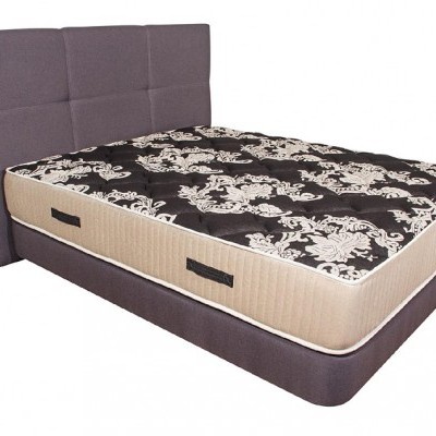 Cama com cabeceira cinza e colchão floral preto e bege
