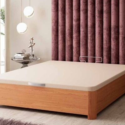 Cama de madeira clara com colchão bege e cabeceira roxa em quarto moderno