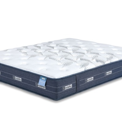 Colchão branco matelassado com bordas azuis e etiquetas laterais