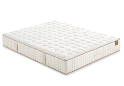 Colchão branco acolchoado com bordas bege e etiqueta marrom.