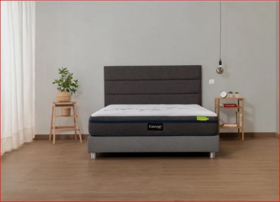 Cama de casal com colchão branco e base cinzenta num quarto minimalista