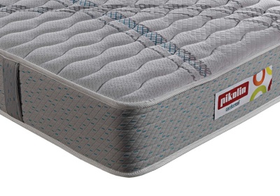 Colchão cinzento acolchoado com padrão ondulado e etiqueta Pikolin
