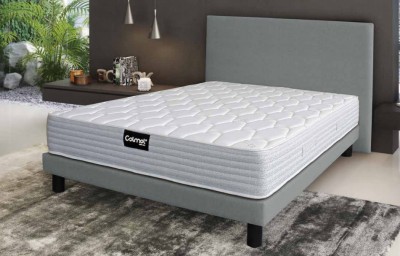 Cama com colchão branco e estrutura cinza numa sala moderna