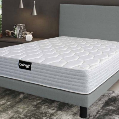 Colchão branco acolchoado sobre estrutura de cama cinza em quarto moderno