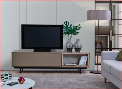 Móvel TV bege com decoração, televisão, lâmpada de pé, sofá e mesa branca redonda.