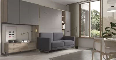 Sala de estar com sofá cinza, móveis de madeira clara, armários cinzentos e janela ampla com vista exterior