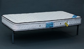 Colchão branco acolchoado com etiquetas azuis e amarelas sobre base preta