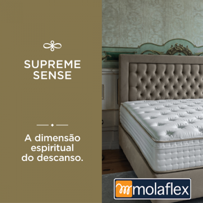 Colchão branco com padrão de costura e cama estofada cinzenta em quarto decorado, texto promocional e logótipo Molaflex.