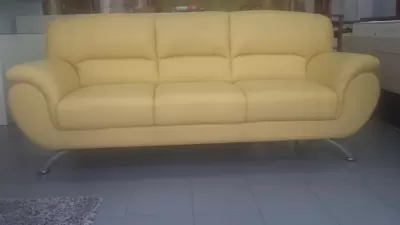 Sofá amarelo de três lugares com base metálica curva