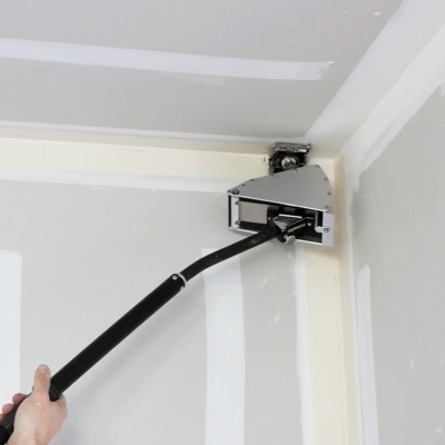 Ferramenta de pintura com cabo longo preto a aplicar no canto do teto e parede