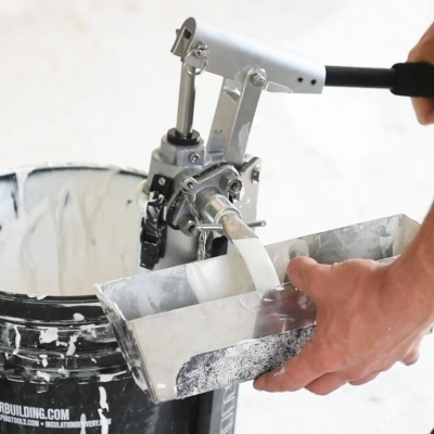 Máquina manual para argamassa com depósito recolhendo material branco