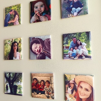 Nove quadros quadrados com fotos de família fixados numa parede