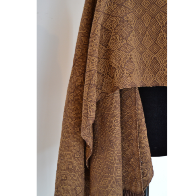 Pano castanho com padrão geométrico pendurado num manequim